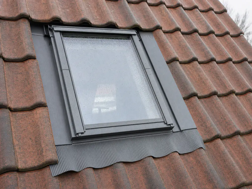 Dakraam met het gootstuk eromheen, ingewerkt tussen de dakpannen