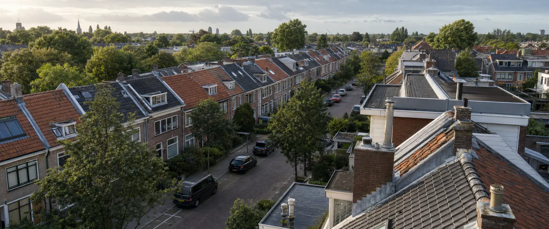 Rij Zuid-Hollandse woningen van bovenaf gezien, met pannendaken, dakkapellen en schoorstenen
