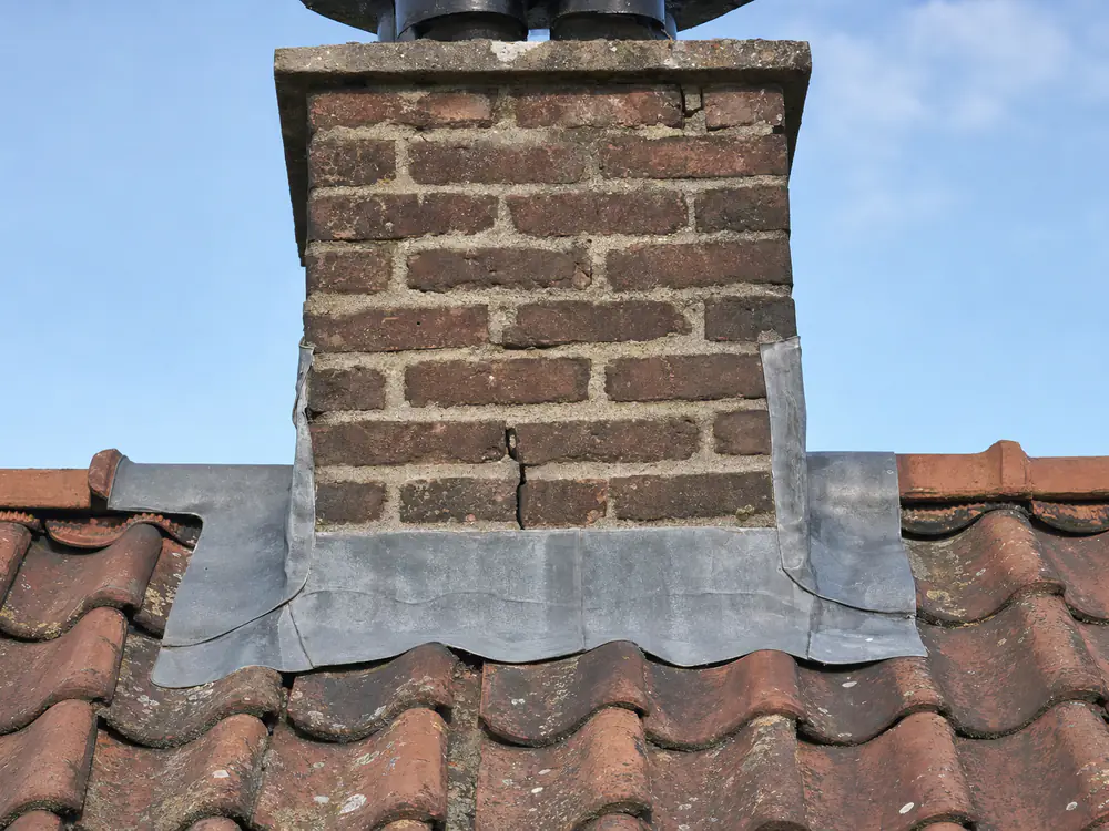Loodwerk rond een schoorsteen, met een opengescheurde voeg
