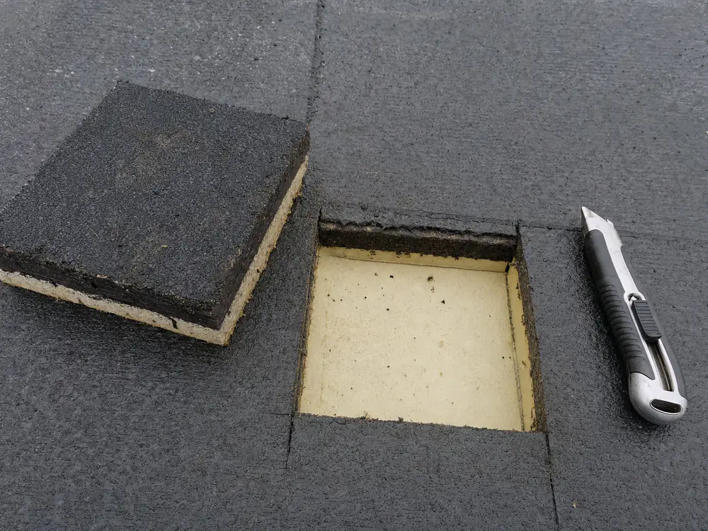 Proefsnede in een plat dak: twee lagen bitumen met de isolatie eronder