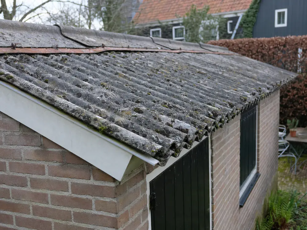 Oude schuur met verweerde grijze golfplaten op het dak