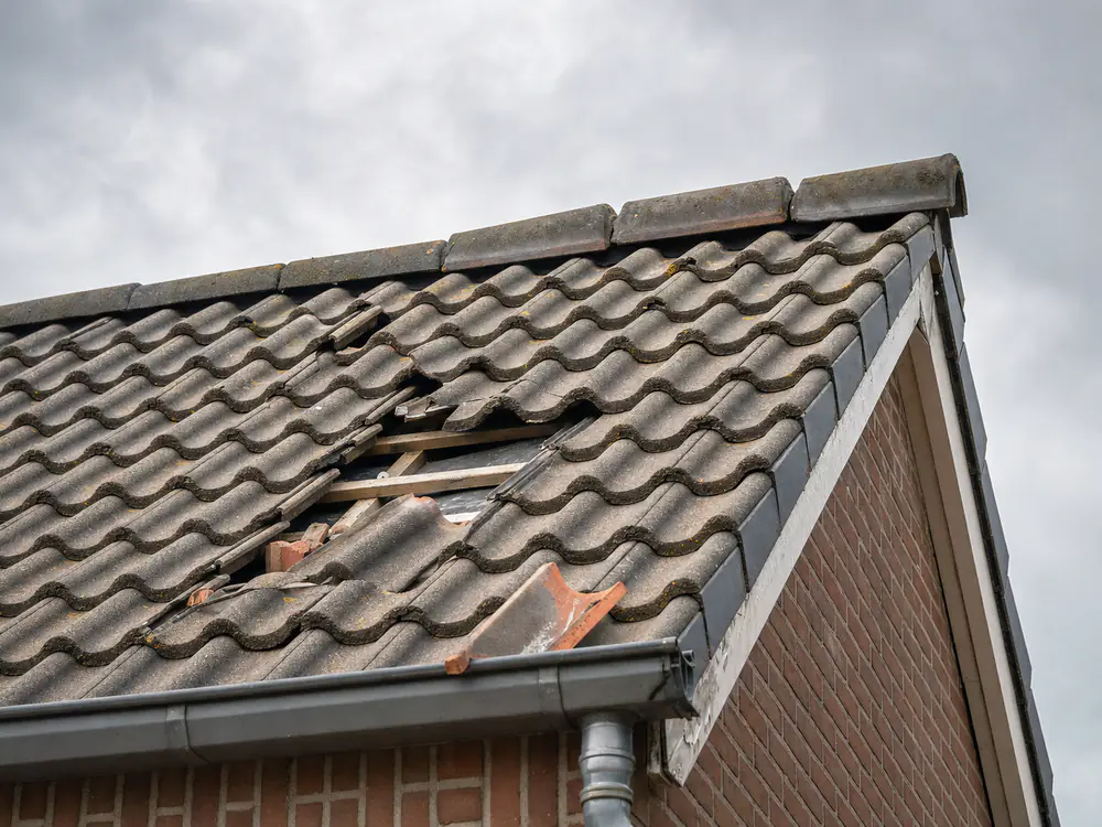Stormschade met verschoven pannen en een losgeraakte nokvors