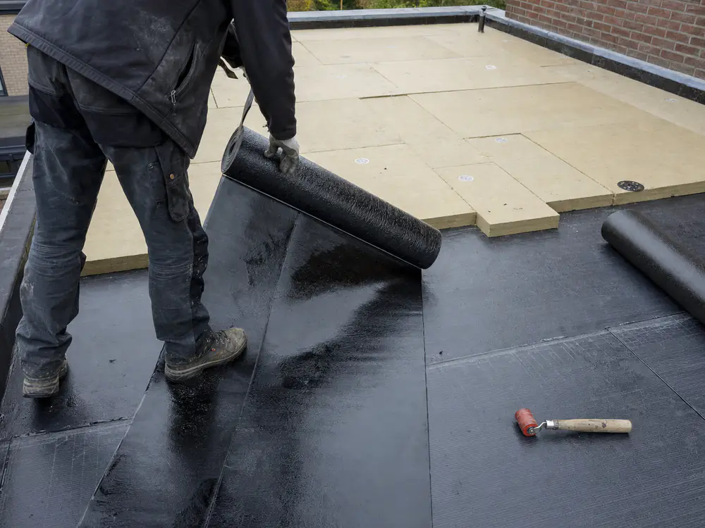 Dakdekker legt nieuwe dakbedekking op een plat dak