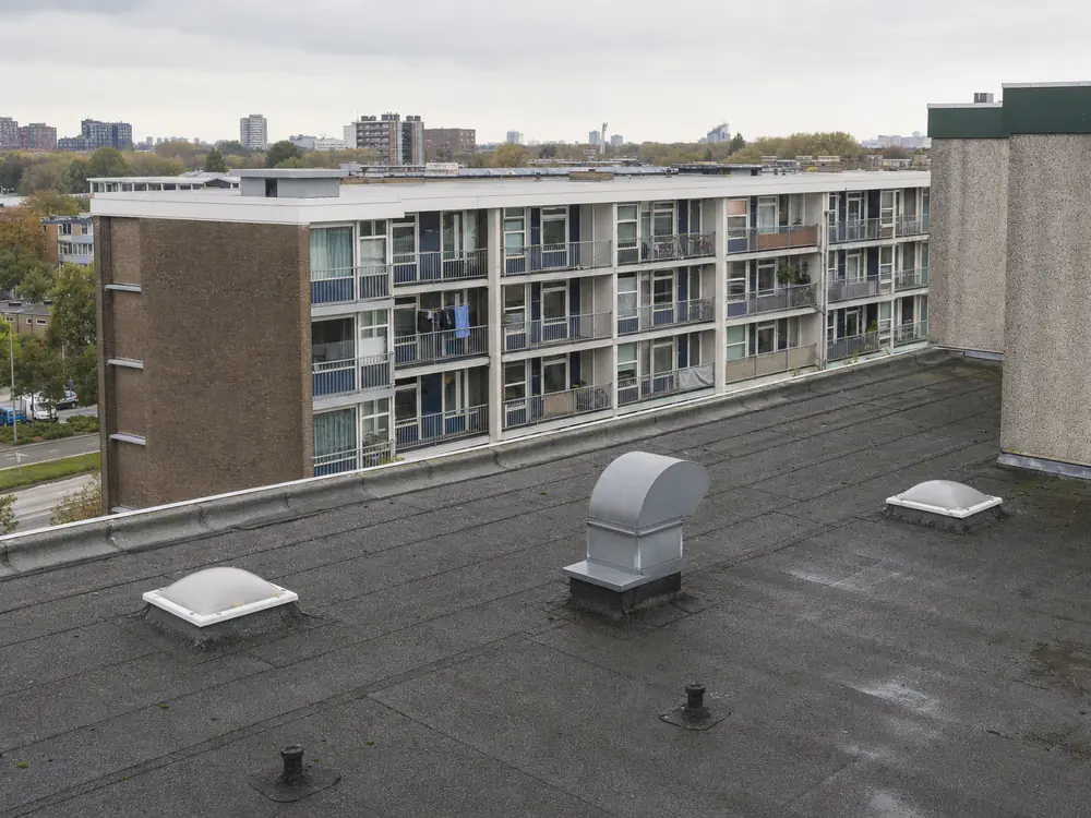 Plat dak van een jaren-60 portiekflat met daklichten en afvoeren