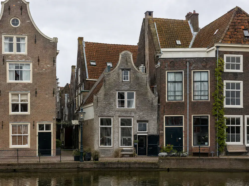 Historische grachtenpanden met steile pannendaken en gedeelde kilgoten