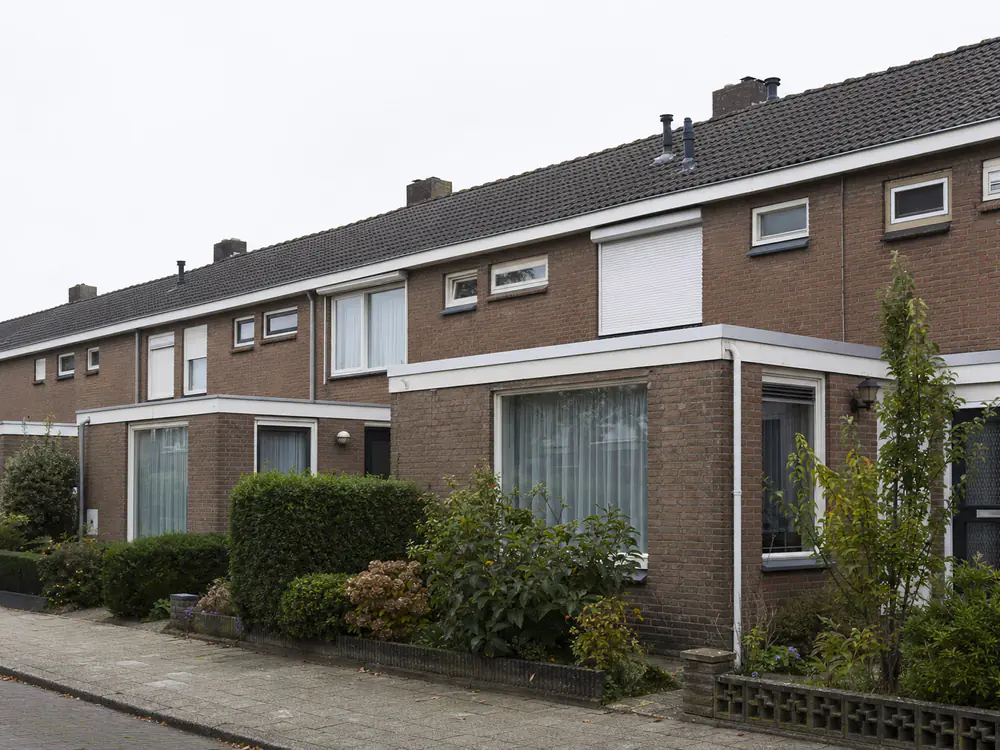 Rij jaren-70 woningen met flauwe pannendaken van betonpannen